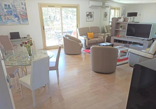 a living room with a table and chairs at Palais Royal, plages à pied, centre St Raphael in Saint-Raphaël