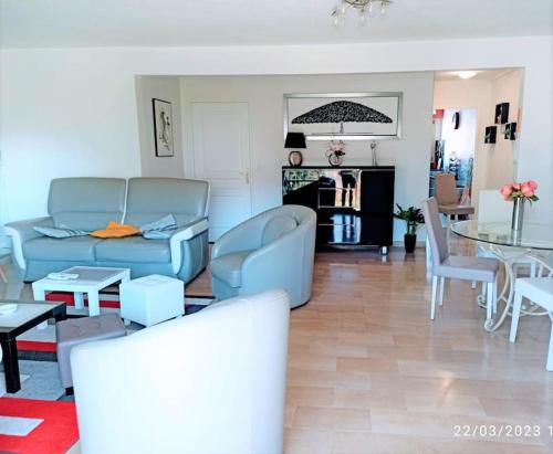 a living room with a blue couch and a table at Palais Royal, plages à pied, centre St Raphael in Saint-Raphaël