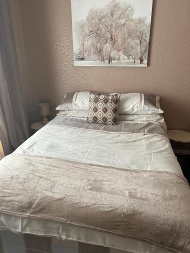 Una cama con sábanas blancas y almohadas en un dormitorio en Village Rooms, en Marton