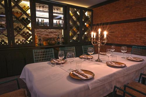 una mesa con mantel blanco y copas de vino en Едно Време en Karlovo