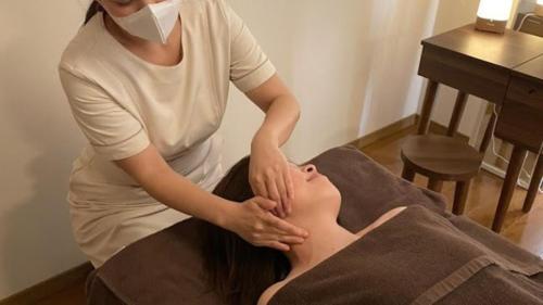 a woman getting a massage on the back of a patient at Shimobe Hotel in Minobu