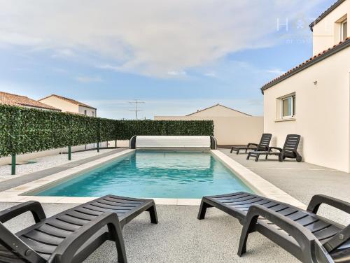 - une piscine avec 2 chaises longues et 2 chaises dans l'établissement Villa 