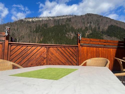 une clôture en bois avec une table, des chaises et une montagne dans l'établissement Gasthof Kögerlwirt, à Göstling an der Ybbs
