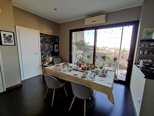 una sala da pranzo con tavolo, sedie e finestra di Casa Vinci a Siracusa