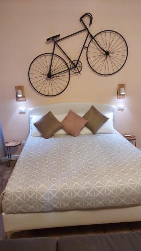 Una bicicleta colgada en la pared sobre una cama en Glam Resort Luxury Lorenzo en La Spezia