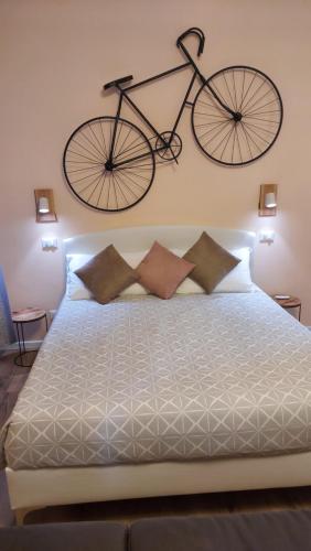 uma bicicleta pendurada na parede acima de uma cama em Glam Resort Luxury Lorenzo em La Spezia