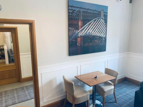 a table with chairs and a picture of a bridge at The Westlynne Apartments in Manchester