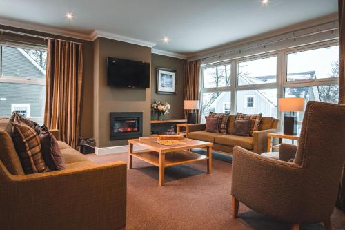 a living room with a couch and a fireplace at Crieff Hydro Self Catering in Crieff