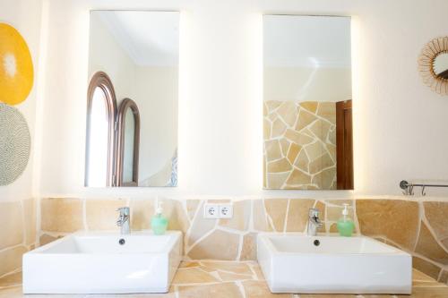ein Badezimmer mit zwei Waschbecken und zwei Spiegeln in der Unterkunft Villa Xapala - Cala Ratjada in Cala Ratjada