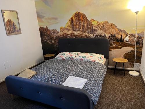 a bedroom with a bed with a mountain mural on the wall at GRAN hostel in Banská Bystrica