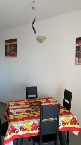 a dining room table with a colorful tablecloth and chairs at Appartamento monolocale vista mare FT6 in Cascabraga