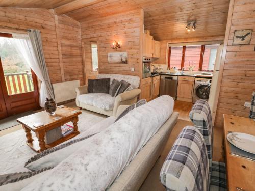 a living room with a large couch in a log cabin at 6 Astbury Falls in Bridgnorth