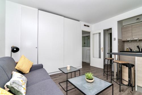 un salon avec un canapé et une table dans l'établissement Les Tambourins By SCLS Locations, à Cannes