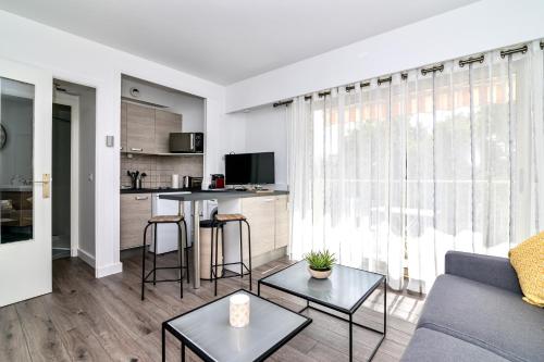 un salon avec un canapé et une table dans l'établissement Les Tambourins By SCLS Locations, à Cannes