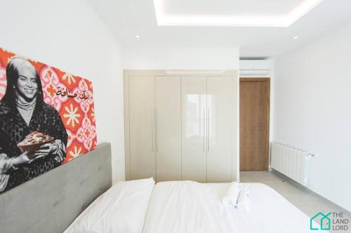 una camera da letto con un letto e un dipinto sul muro di Sunset 204 Luxury 2bds with Gym a Tunisi