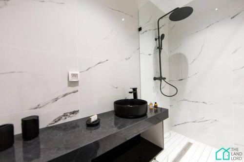 La salle de bains est pourvue d'un lavabo noir et d'une douche. dans l'établissement Sunset 202 Luxury with gym club in Lac 1, à Tunis