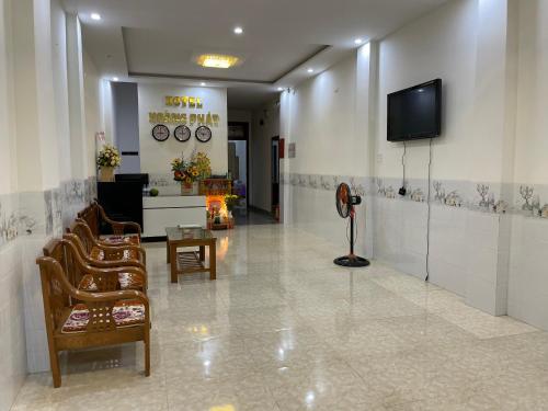 a lobby with chairs and a tv on the wall at Khách sạn Hoàng Phát Quy Nhơn in Quy Nhon