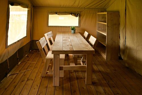 a wooden table and chairs in a tent at Safaritent 2 in Swalmen