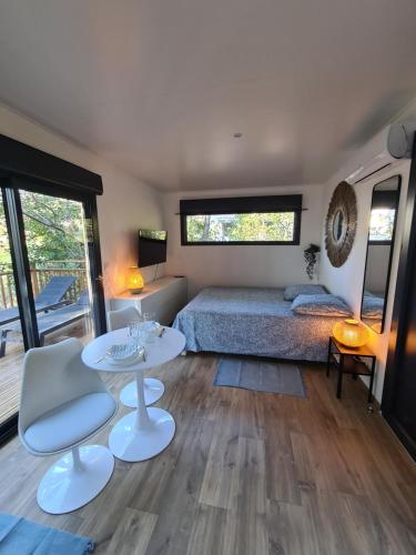 Schlafzimmer mit einem Bett, einem Tisch und Stühlen in der Unterkunft Le Cube in Sommières