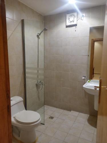 a bathroom with a shower and a toilet and a sink at Nawara Hotel in Riyadh