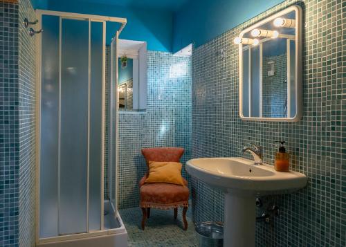 a blue tiled bathroom with a sink and a shower at NEW! La Stanza in Villa in Lucca
