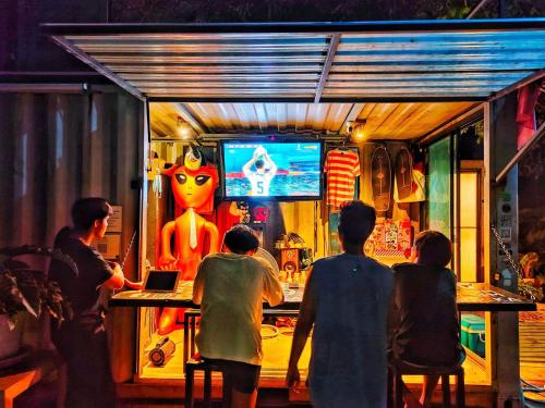 um grupo de pessoas sentadas num bar a ver televisão em SEDS-KANCHANABURI em Ban Chuk Kum