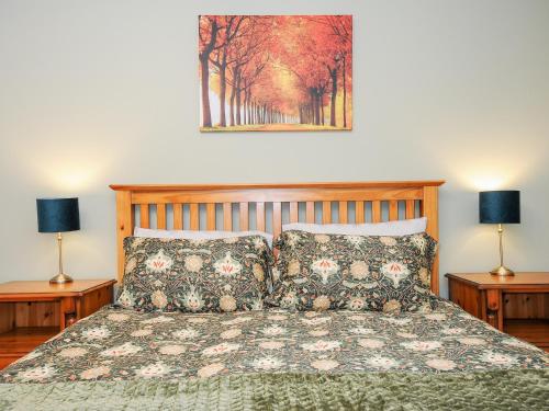 - une chambre avec un lit avec des oreillers et 2 lampes dans l'établissement Owl Barn, à Liskeard
