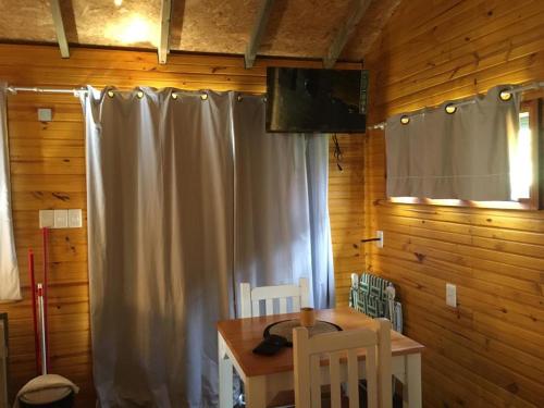 un comedor con una cortina blanca y una mesa en Bahía, en Punta del Diablo