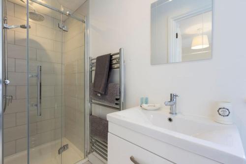 a white bathroom with a sink and a shower at The Willow Studio - peaceful retreat near Whitstable seaside in Kent