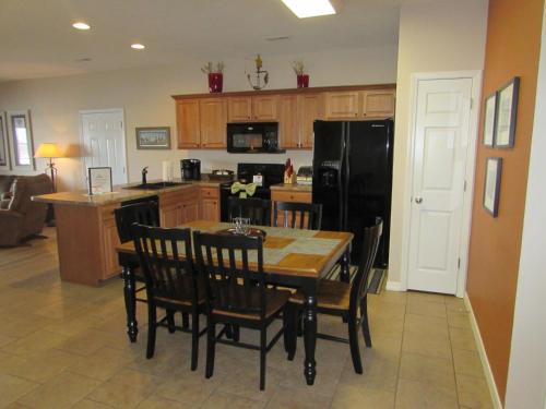 a kitchen with a table and chairs and a black refrigerator at Walk-in Condo A-4 in Hollister