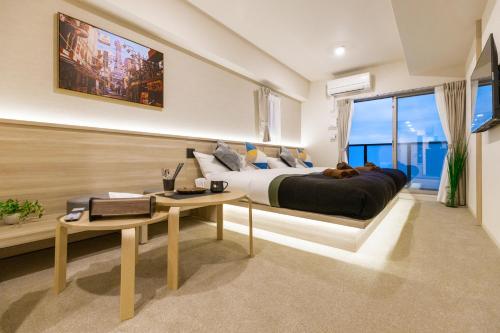 a bedroom with a large bed and a table at Apartment Hotel 11 Kuromon in Osaka