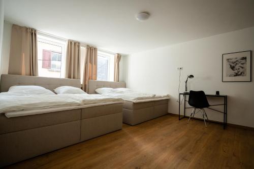 a bedroom with two beds and a chair in it at Old Town Apartment 2 rooms/baths in Düsseldorf