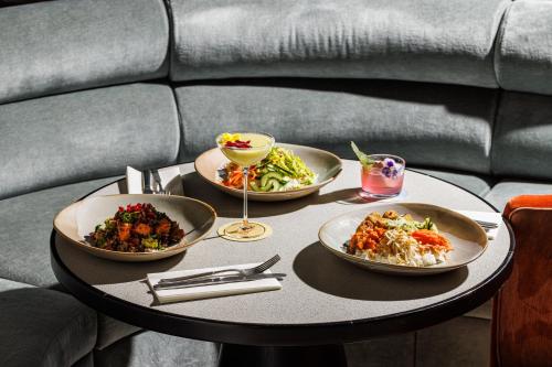 a table with three plates of food on it at TRIBE London Canary Wharf in London
