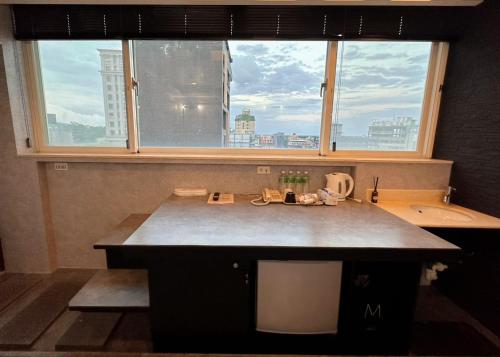 a kitchen with a sink and a large window at 沐-湯宿溫泉行旅 in Jiaoxi