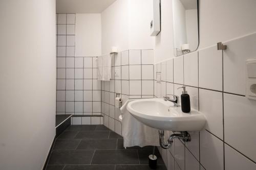 a white bathroom with a sink and a mirror at Old Town Apartment 2 rooms/baths in Düsseldorf