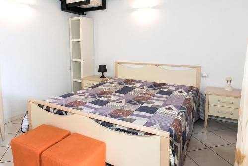 1 dormitorio con cama y taburete de color naranja en N036 - Numana, bilocale con terrazzo in residence con piscina, en Numana