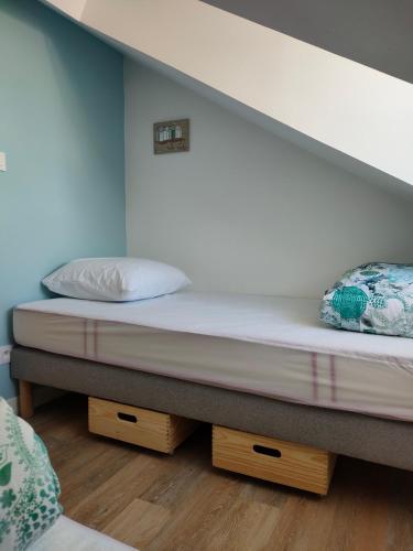 a bed with two pillows on it in a room at L'intemporelle in Le Crotoy