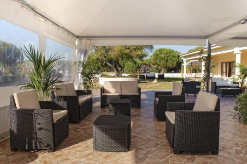 a group of chairs and tables under a white tent at Hotel Petri Marini in Aglientu