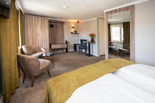 a hotel room with a bed and a living room at Hotel Botterweck in Valkenburg