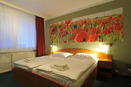 a bedroom with a bed with two towels on it at Hotel Krystal in Hodonín