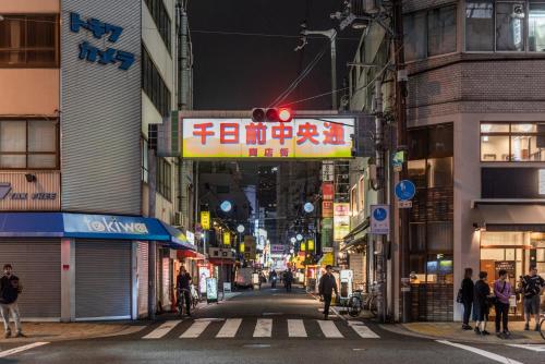 a city street at night with a red traffic light at Apartment Hotel 11 Kuromon in Osaka