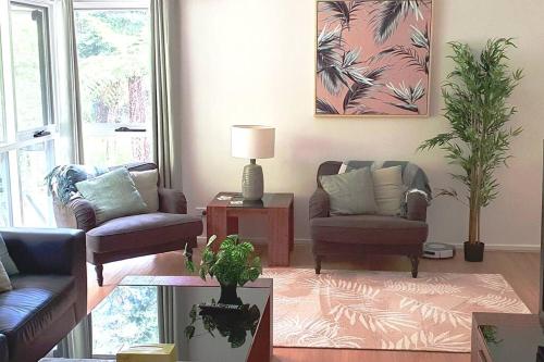 a living room with two chairs and a table at Grey Gum Getaway Tecoma in Belgrave