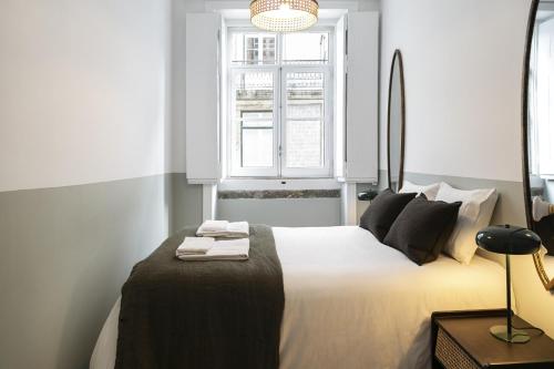 une chambre avec un grand lit blanc avec une fenêtre dans l'établissement Downtown Flat with Design and Comfort at Downtown, 3rd-floor no lift, à Lisbonne