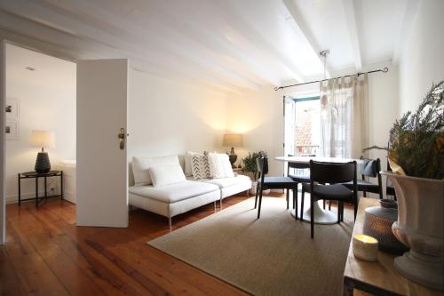 un salon avec un canapé blanc et une table dans l'établissement Chic Urban Retreat at Downtown with Balcony & Views, 5th-floor no lift, à Lisbonne