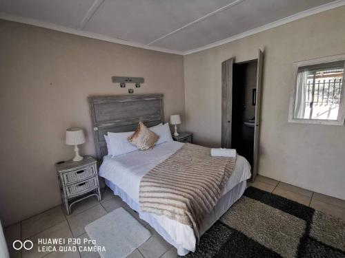 um quarto com uma cama grande e uma janela em Akkerdam Bed and Breakfast em Calvinia