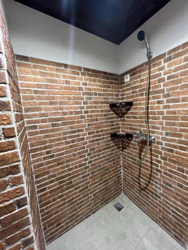 a bathroom with a brick wall with a shower at Choska Residence in Jakarta