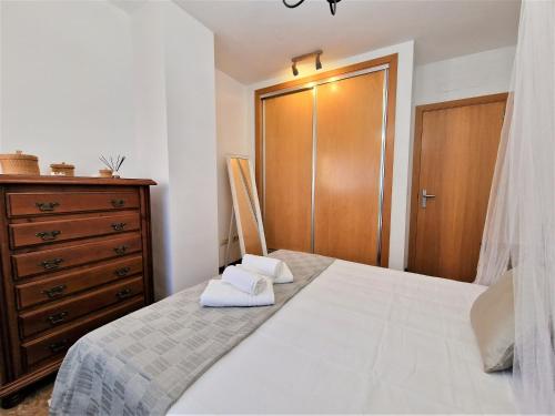 1 dormitorio con cama blanca y armario de madera en DS Dúplex Acera del Río, parking opcional, en Córdoba