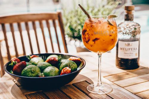 - un bol de fruits et une boisson sur une table en bois dans l'établissement Maison des Ambassadeurs, à La Rochelle