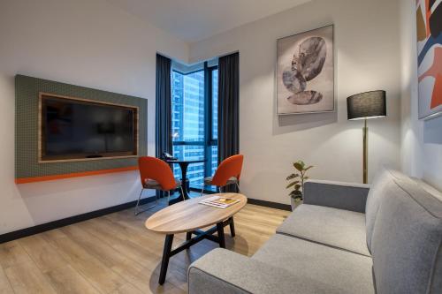 a living room with a couch and a table and a tv at INNSiDE by Meliá Kuala Lumpur in Kuala Lumpur