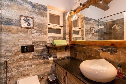 a bathroom with a sink and a mirror at SaffronStays Farsouli 1° in Bhowāli